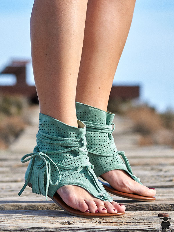 Vista lateral de sandalias boho chic verdes con correas ajustables
