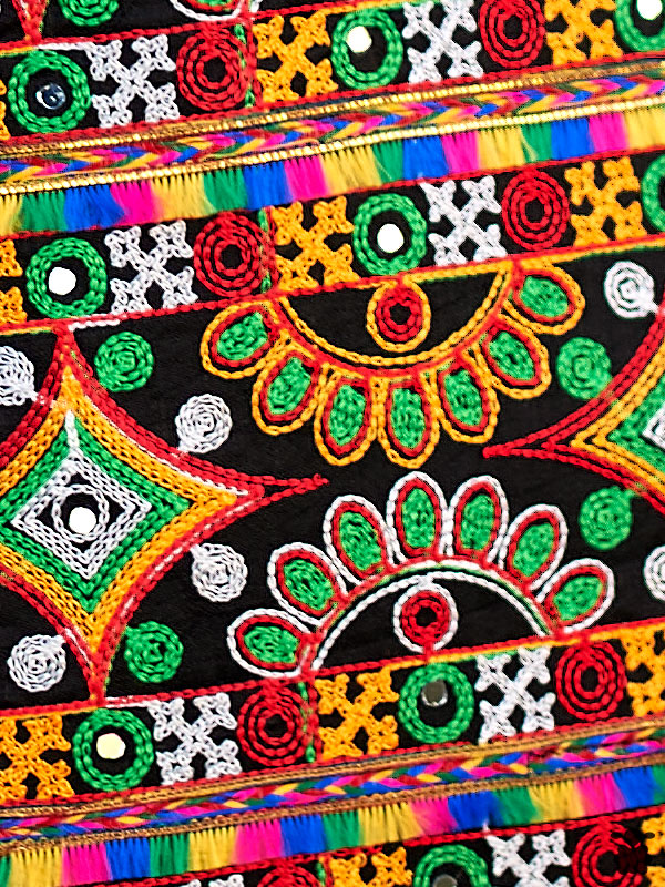 bolso-indio-floral1 Detalle del intrincado bordado floral del Bolso Indio Floral con aplicaciones de espejos y franjas de flecos multicolores en rosa, azul y amarillo